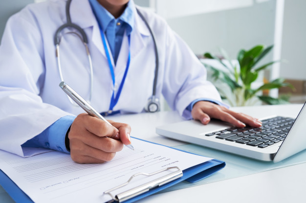 hands unrecognizable female doctor writing form typing laptop keyboard 1098 20374