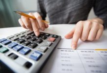 closeup accountant hands counting calculator