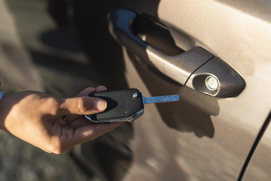 businesswoman using key unlock her car