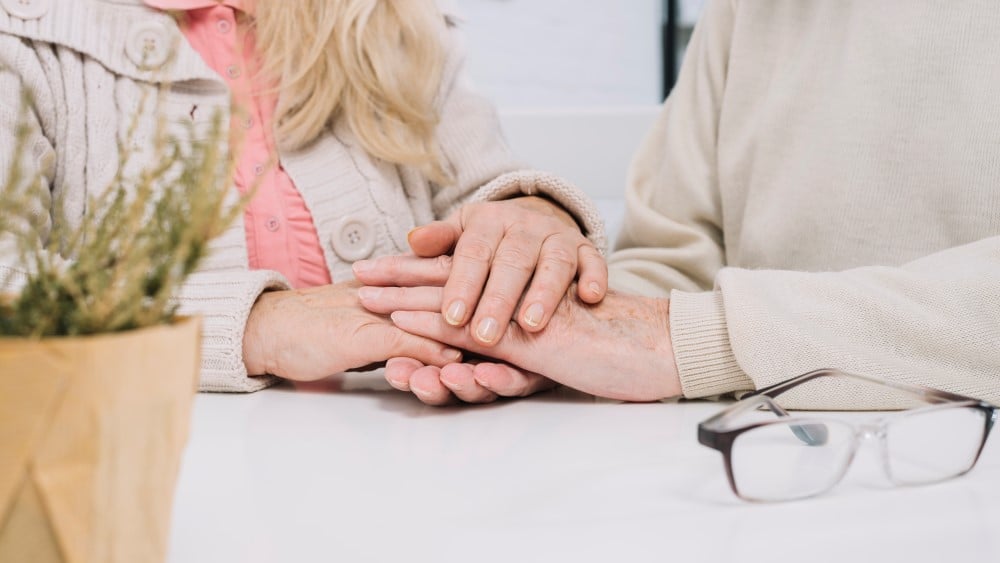 senior couple table holding hands