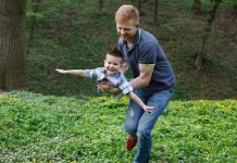 dad whirls his son like airplane playing green park 8353 5362