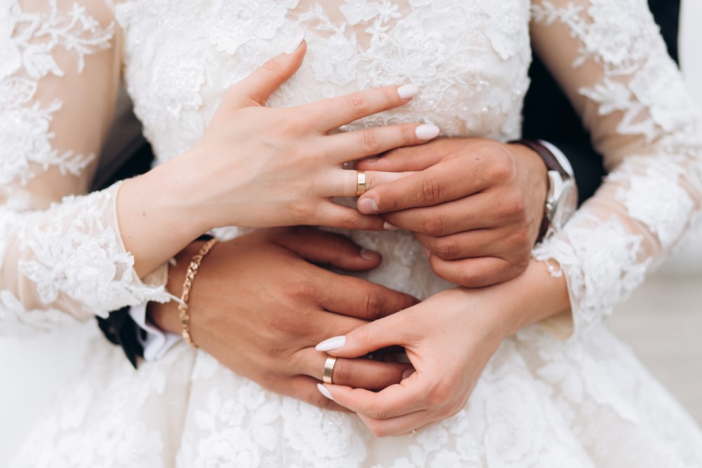 groom bride are putting wedding rings front view hands