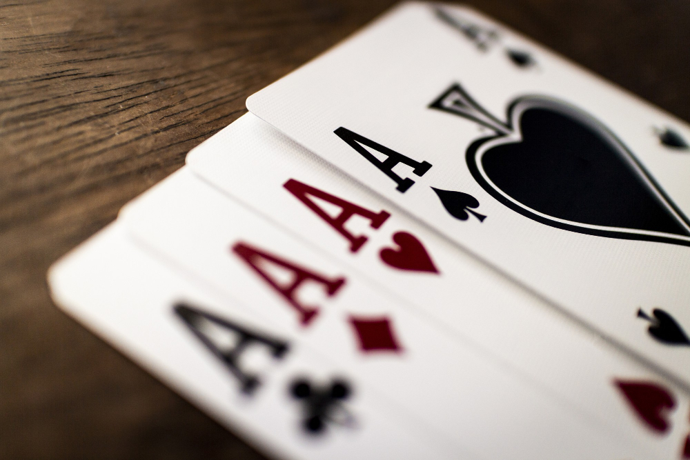 selective focus shot four aces wooden table