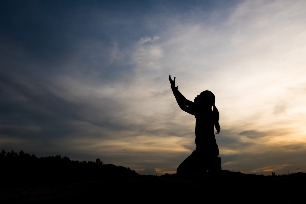 silhouette woman praying with god