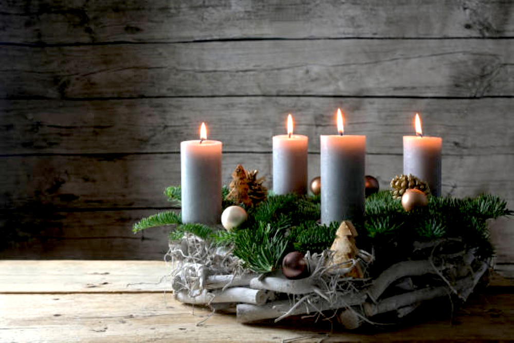 rustic advent wreath of wood fir branches and christmas decoration with four burning candles