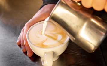 close up barista pouring coffee into cup